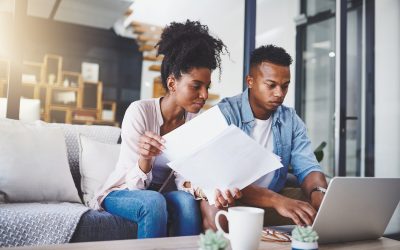 Couple on couch with papers and laptop