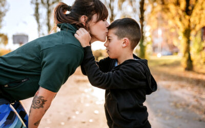 Mom kisses son on forehead in the park