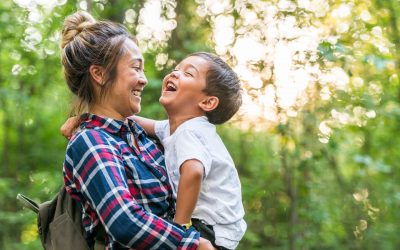 Asian American mom holds young son outdoors