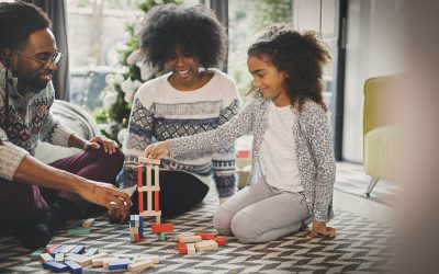 Black family plays with blocks in the living room